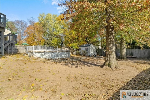 view of yard with a pool side deck and a storage shed