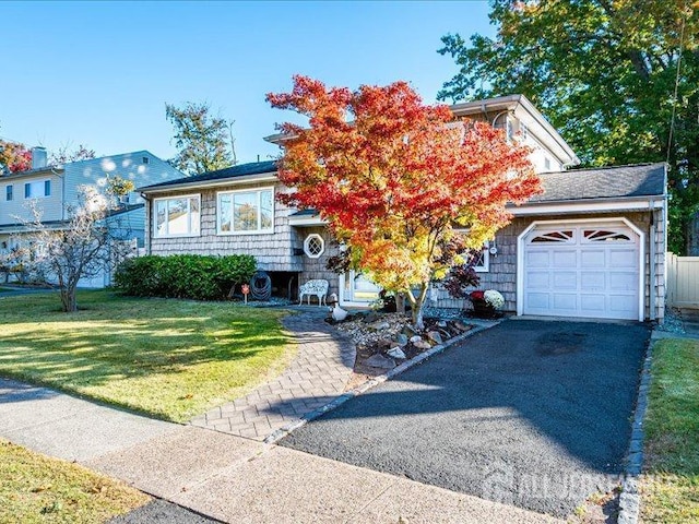 view of front of property featuring a front lawn, a garage, and driveway