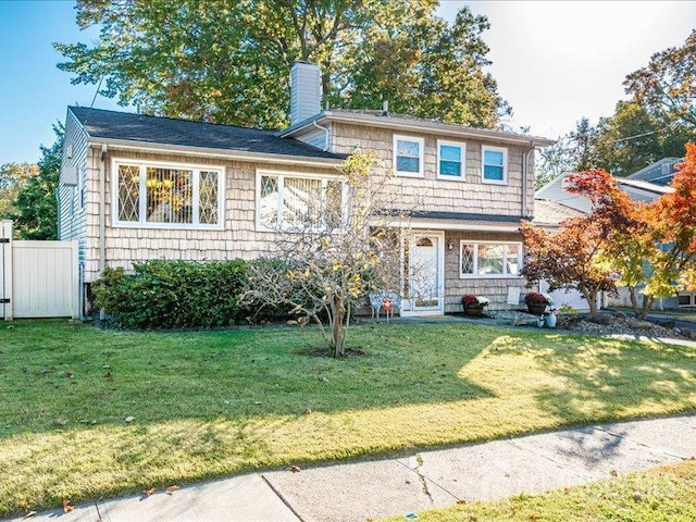 split level home featuring a chimney and a front lawn