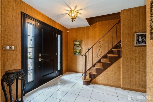 tiled foyer entrance featuring wooden walls