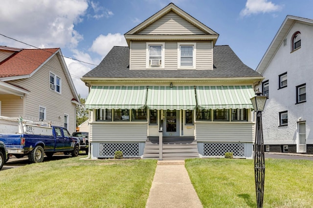 view of front of home featuring entry steps, a shingled roof, and a front lawn