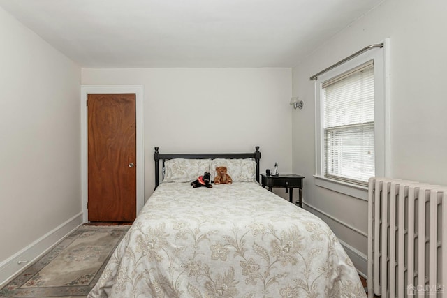 bedroom with baseboards and radiator