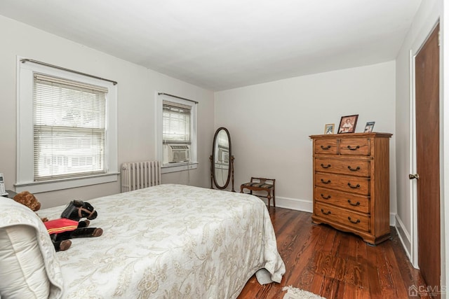 bedroom featuring dark wood finished floors, cooling unit, radiator, and baseboards