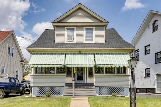 view of front of home with a front lawn and a shingled roof