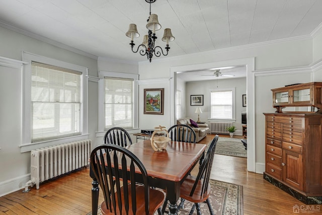 dining area featuring ornamental molding, radiator, and hardwood / wood-style floors