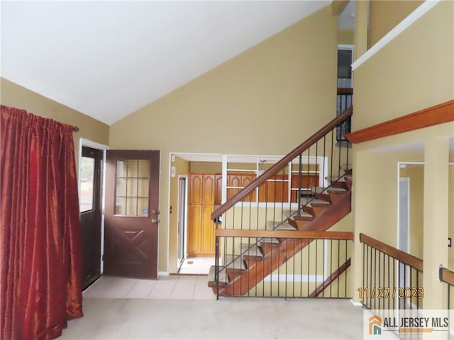 staircase featuring carpet and high vaulted ceiling