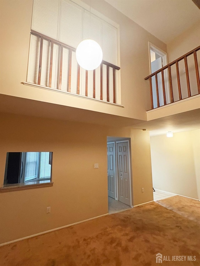 12 Excalibur Ct, Old Bridge, NJ 08857 - unfurnished living room with carpet flooring, a high ceiling, and baseboards