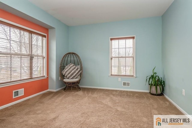 unfurnished room featuring plenty of natural light, baseboards, visible vents, and carpet floors