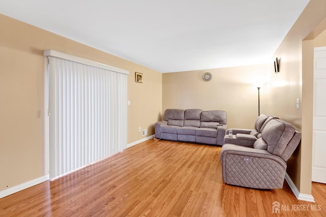 living area with light wood-type flooring and baseboards