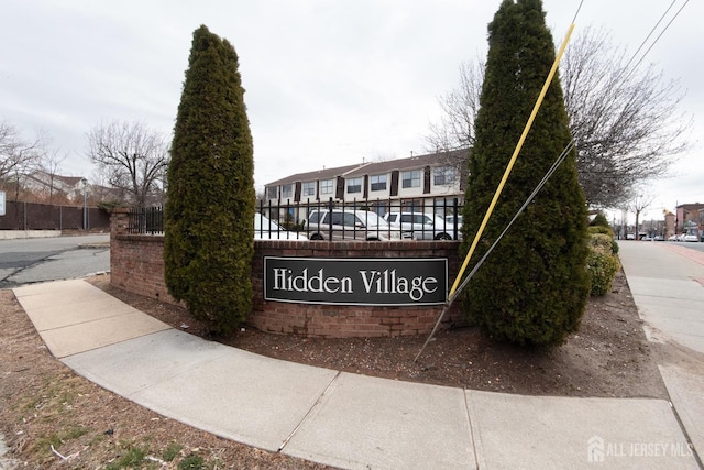 community / neighborhood sign with a residential view