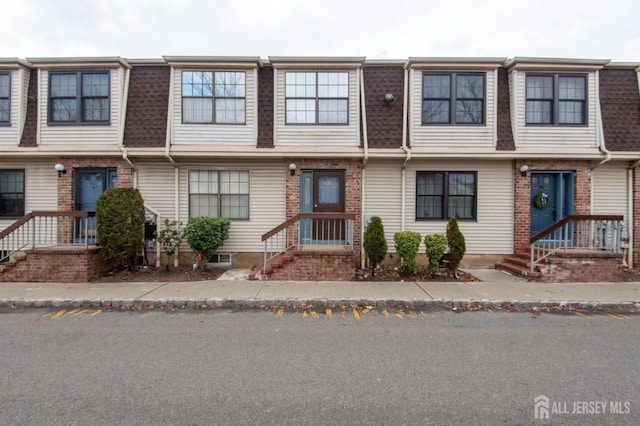 townhome / multi-family property featuring mansard roof and roof with shingles