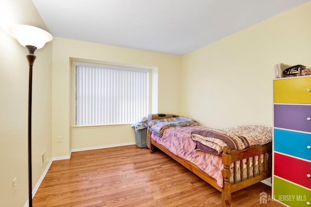 bedroom featuring baseboards and wood finished floors