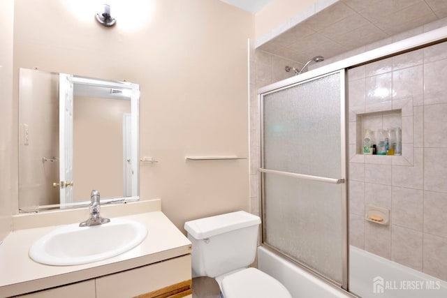 full bathroom with vanity, toilet, and bath / shower combo with glass door