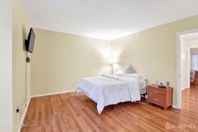 bedroom with light wood finished floors and baseboards