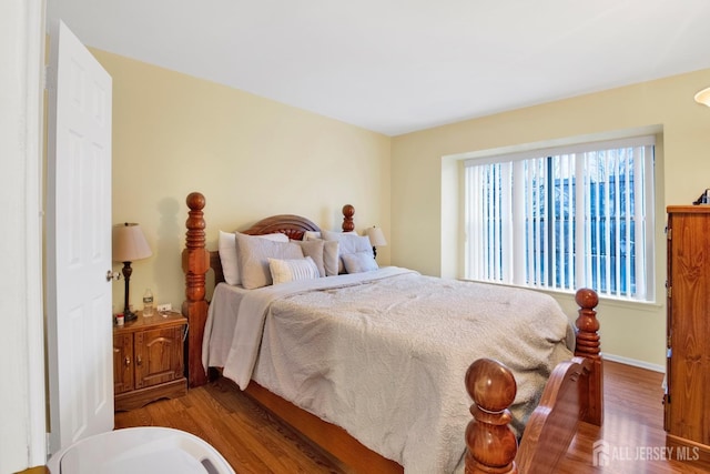 bedroom featuring baseboards and wood finished floors