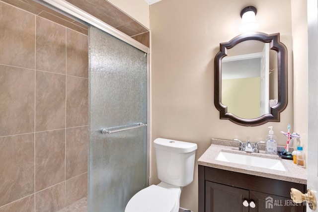 bathroom featuring a stall shower, vanity, and toilet