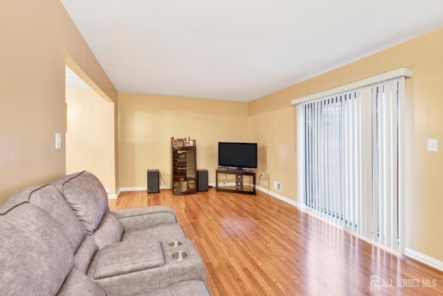 living area featuring wood finished floors, visible vents, and baseboards