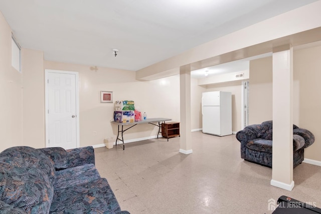 living area with tile patterned floors, visible vents, and baseboards