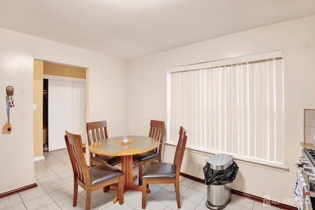 dining area featuring light tile patterned floors and baseboards