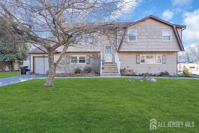 bi-level home featuring a garage, a front lawn, and driveway