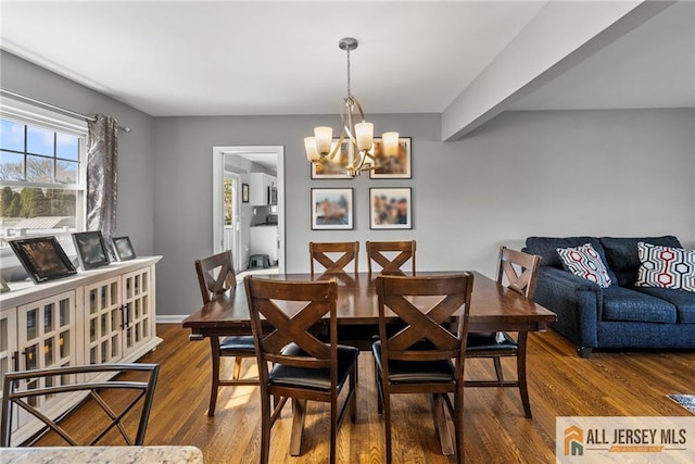dining area featuring baseboards, a chandelier, and wood finished floors
