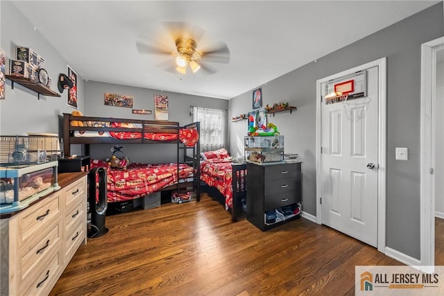 bedroom with a ceiling fan, wood finished floors, and baseboards