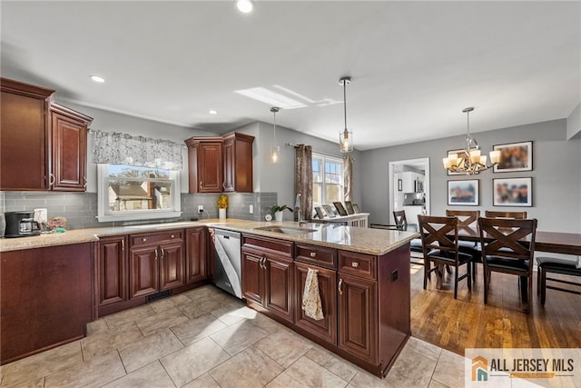 kitchen with a sink, a peninsula, dishwasher, pendant lighting, and backsplash