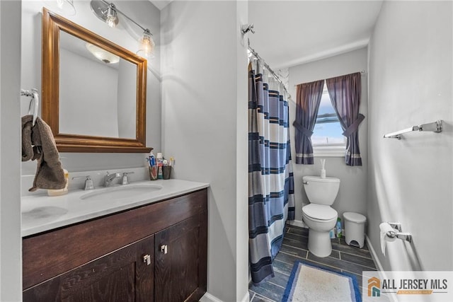 full bathroom featuring toilet, curtained shower, baseboards, and vanity