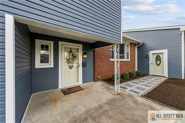 doorway to property featuring brick siding