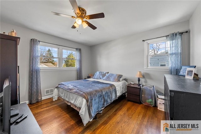 bedroom featuring visible vents, wood finished floors, baseboards, and ceiling fan