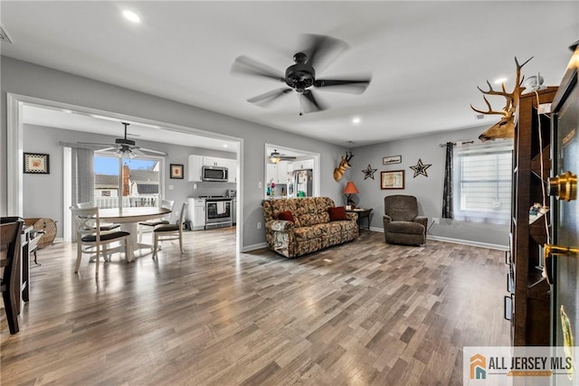 living area with a healthy amount of sunlight, wood finished floors, and ceiling fan