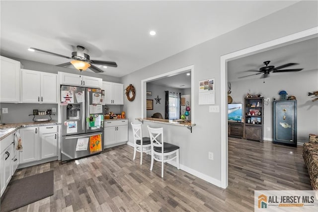 kitchen featuring white cabinetry, wood finished floors, a ceiling fan, and stainless steel refrigerator with ice dispenser