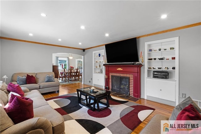 235 Brook Ave, North Plainfield, NJ 07060 - living room featuring wood finished floors, arched walkways, crown molding, built in shelves, and recessed lighting