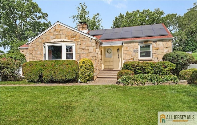 235 Brook Ave, North Plainfield, NJ 07060 - view of front of home with stone siding, a front lawn, and solar panels