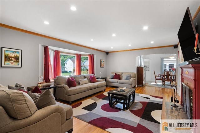 235 Brook Ave, North Plainfield, NJ 07060 - living area with ornamental molding, arched walkways, light wood finished floors, recessed lighting, and a fireplace with flush hearth
