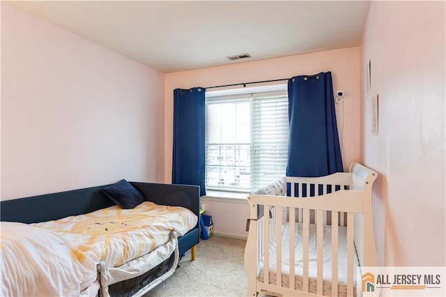 carpeted bedroom featuring baseboards and visible vents