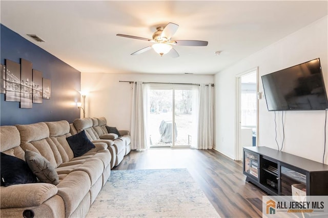 living area featuring wood finished floors, visible vents, and ceiling fan