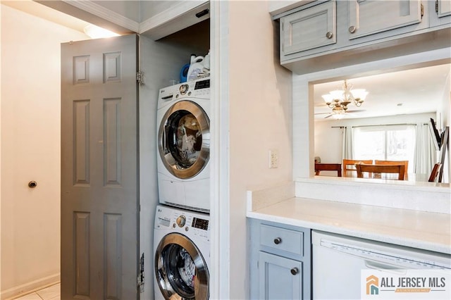 laundry area featuring a notable chandelier and stacked washer and dryer