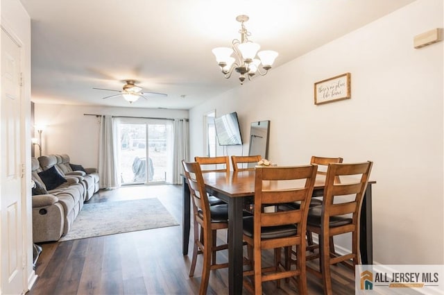 dining area with wood finished floors and ceiling fan with notable chandelier