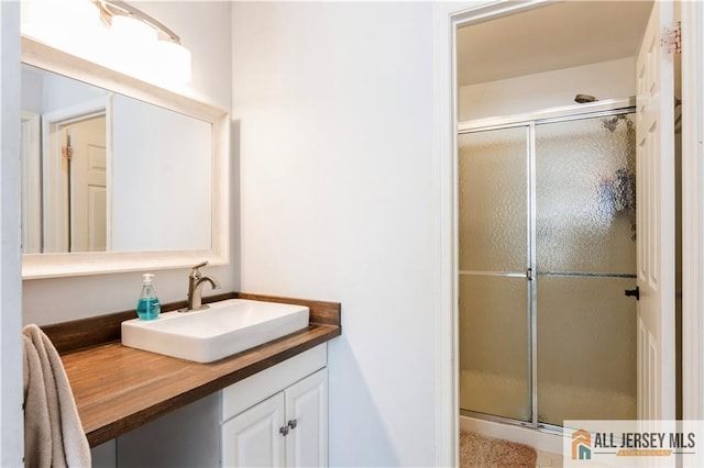 full bath with a shower stall and vanity