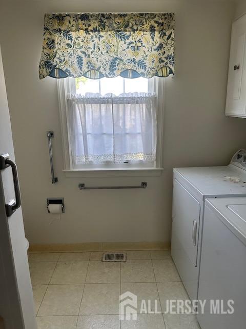 71 Rossmoor Dr Unit B, Monroe, NJ 08831 - washroom with separate washer and dryer, cabinet space, baseboards, and light tile patterned floors
