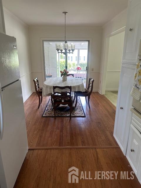 71 Rossmoor Dr Unit B, Monroe, NJ 08831 - dining room featuring a chandelier, wood finished floors, baseboards, and crown molding