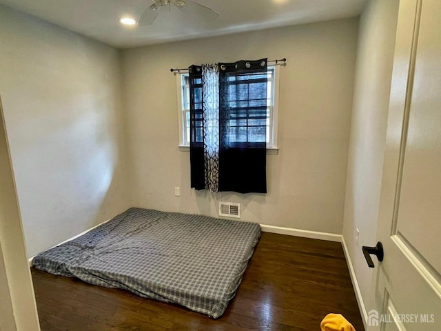 bedroom with baseboards, wood finished floors, visible vents, and recessed lighting