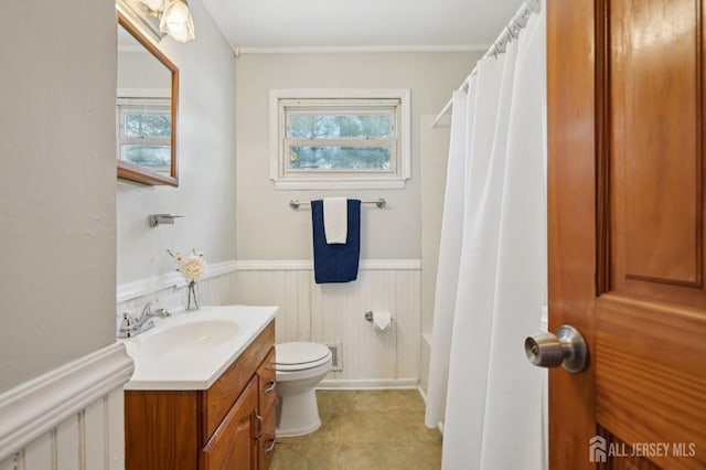 full bath with visible vents, shower / bath combo with shower curtain, toilet, wainscoting, and vanity