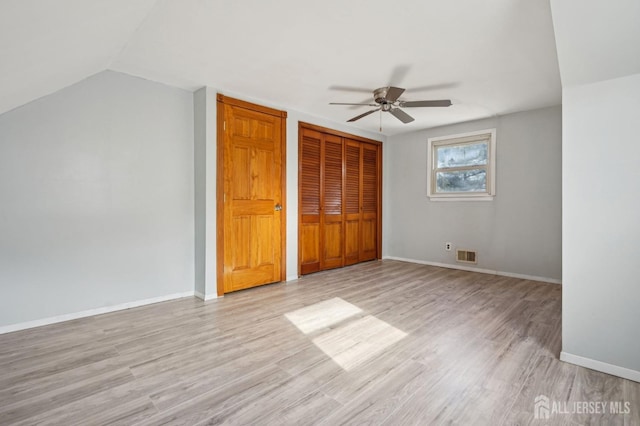 unfurnished bedroom featuring wood finished floors, visible vents, a closet, and baseboards