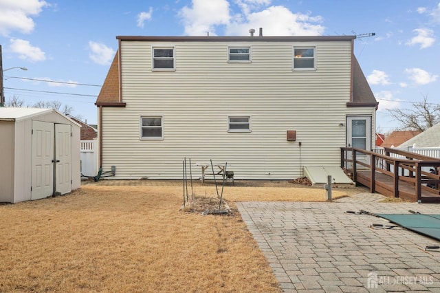 back of house featuring an outbuilding, a yard, a shed, and a wooden deck