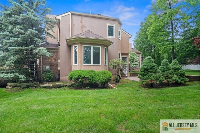 124 Kingsland Cir S, Brunswick, NJ 08852 - back of property with stucco siding and a yard