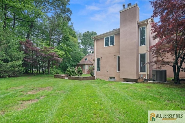 124 Kingsland Cir S, Brunswick, NJ 08852 - back of house featuring a chimney, a yard, and stucco siding