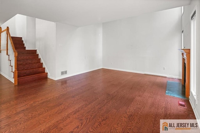 124 Kingsland Cir S, Brunswick, NJ 08852 - unfurnished living room with wood finished floors, stairway, and a fireplace with flush hearth