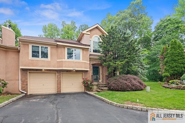 124 Kingsland Cir S, Brunswick, NJ 08852 - view of front of house featuring asphalt driveway, stucco siding, a garage, a front lawn, and brick siding